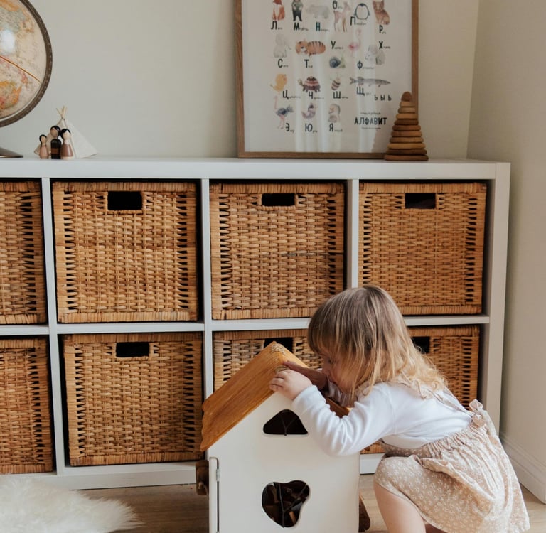 Little girl with play house in front of IKEA Kallax unit with wicker baskets
