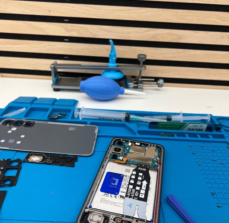 Réparation technique d'un téléphone portable en atelier. Gros plan sur l'intérieur d'un smartphone