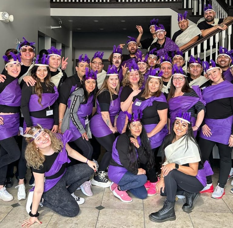 A large group of people in purple and black costumes posing together for a group photo.