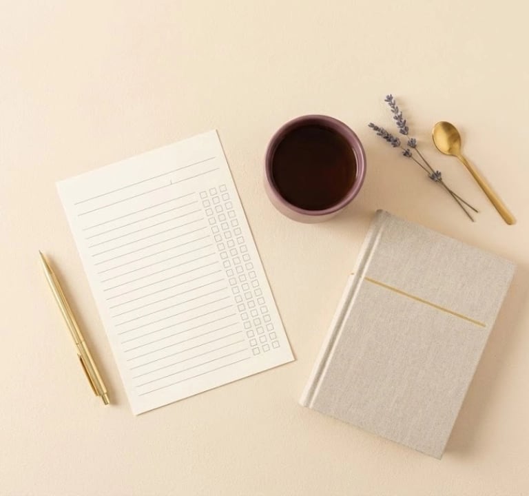Minimal flat lay of a blank sleep tracker sheet and notebook, representing a 14-day tracking method.