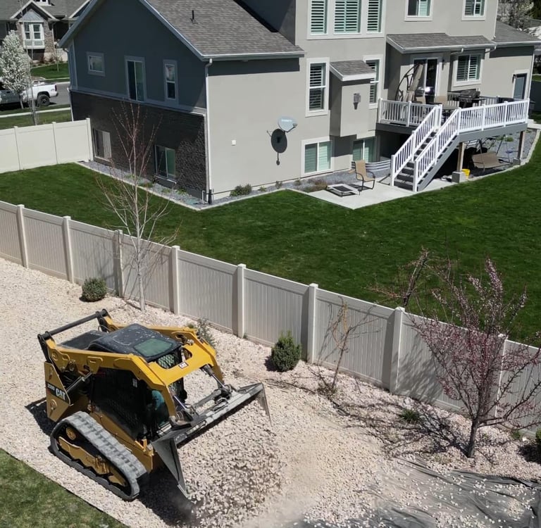 skid steer dumping landscape rock at residential home 