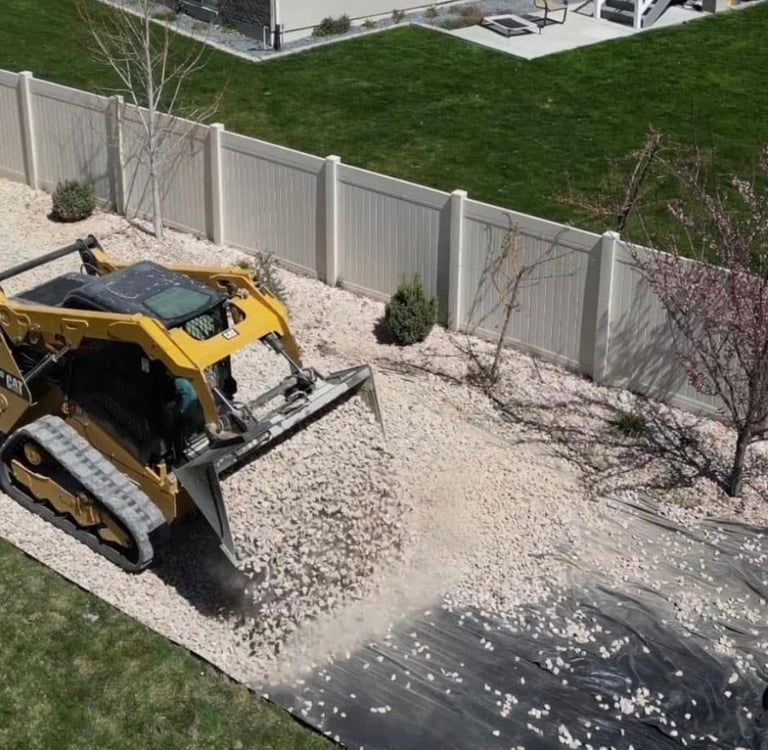 skid steer dumping landscape rock at residential home 
