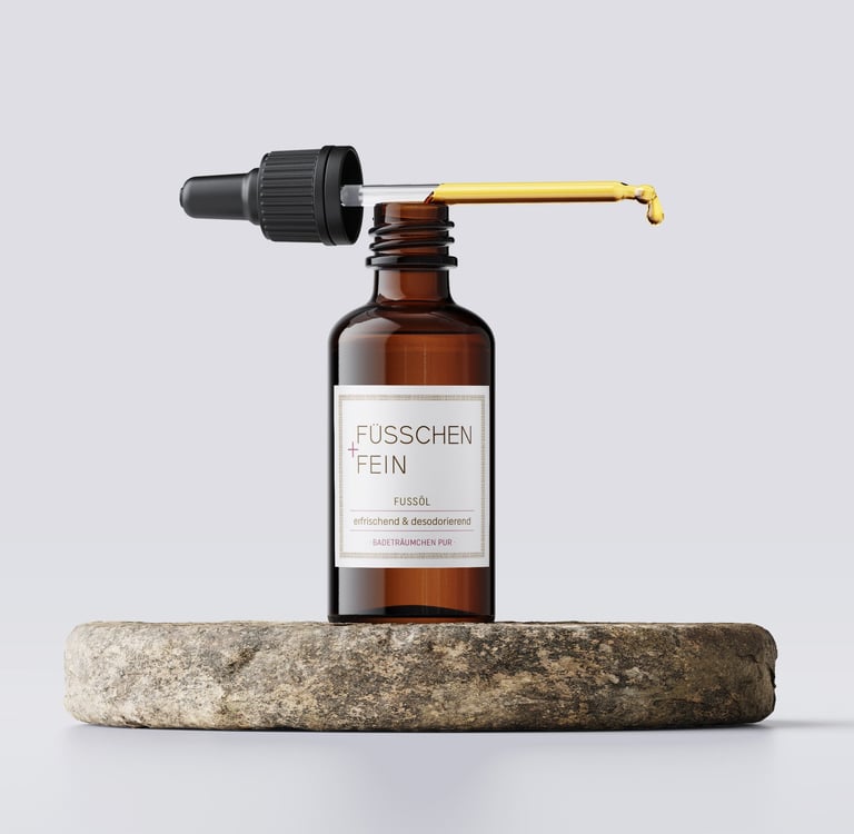 Amber glass dropper bottle with Fußöl essential oil for foot care on a natural stone base.