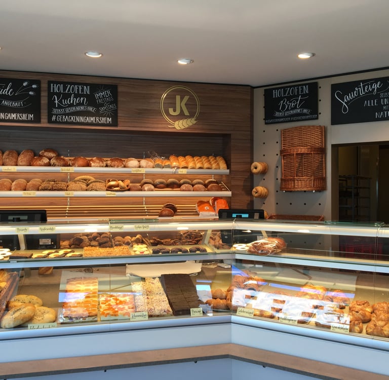 German bakery interior with fresh sourdough bread loaves and artisanal pastries on display shelves.
