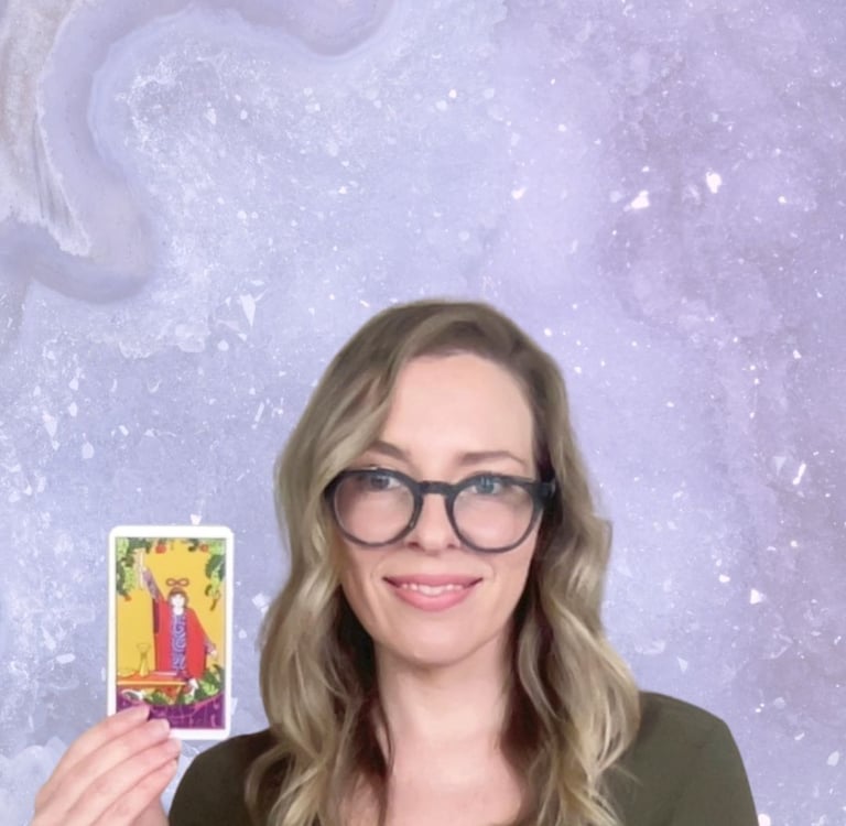 Natalie Grace, founder of Crystal aura Tarot, holding The Magician Card with amethyst background
