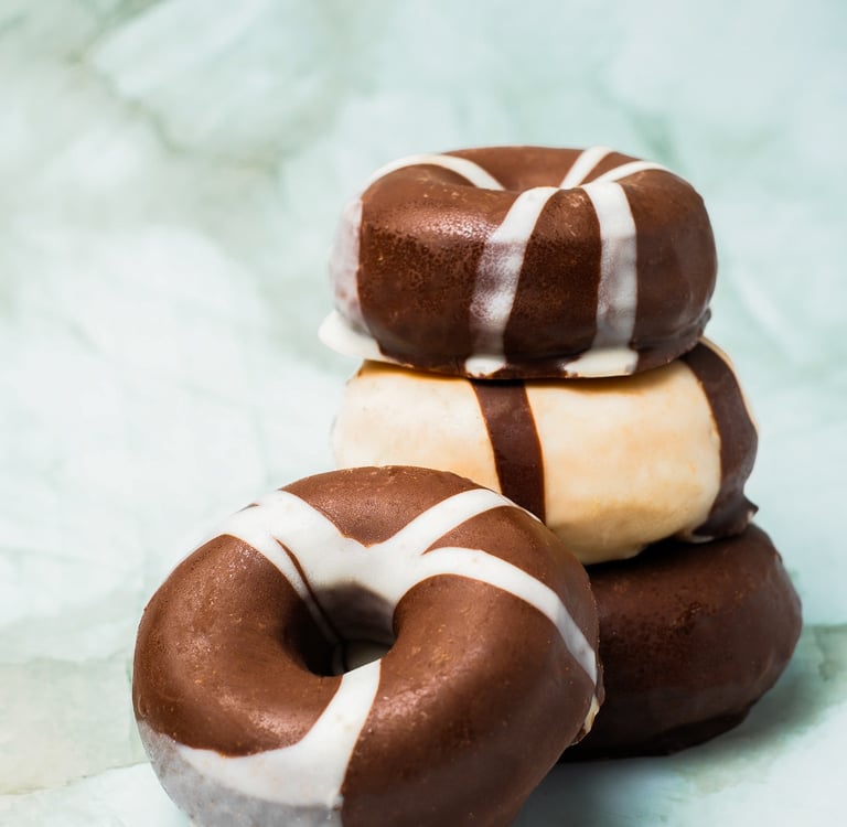 a stack of chocolate covered donuts with chocolate frosting