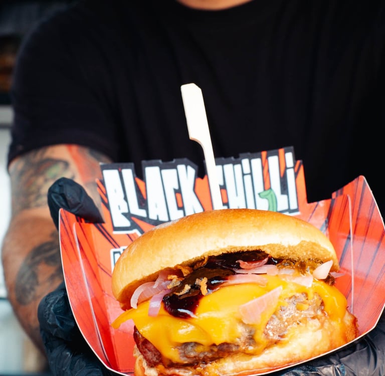 a man holding a large hamburger burger on a paper plate