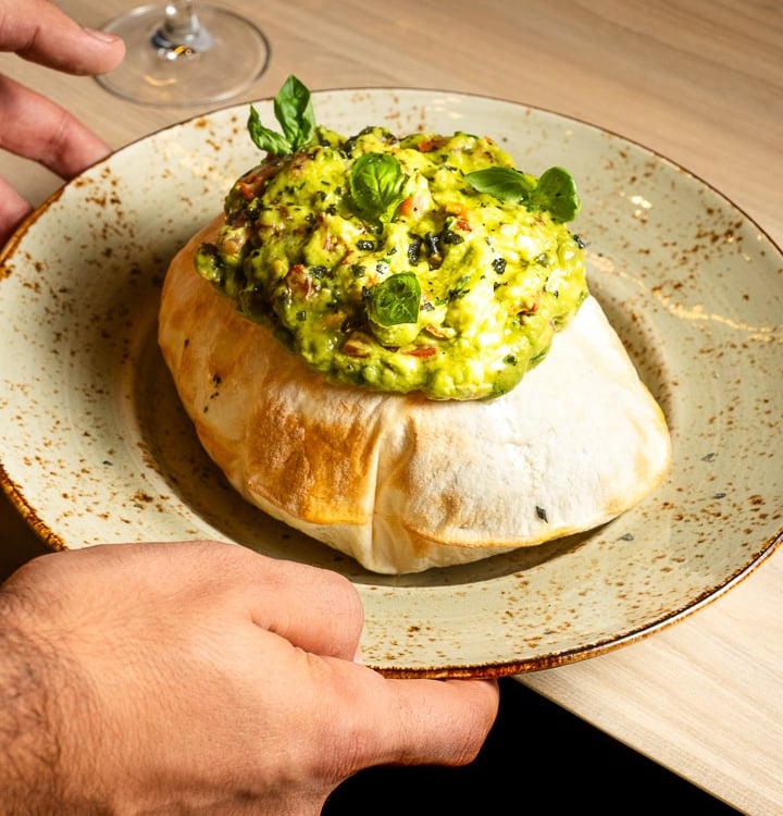 a person holding a plate with a bowl of food