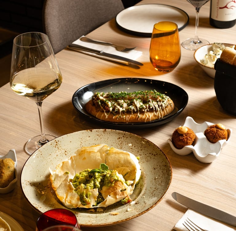 a table with plates of food and wine glasses