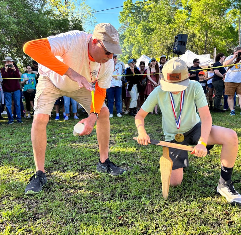 A man shows a young boy how to "grunt" for earthworms.