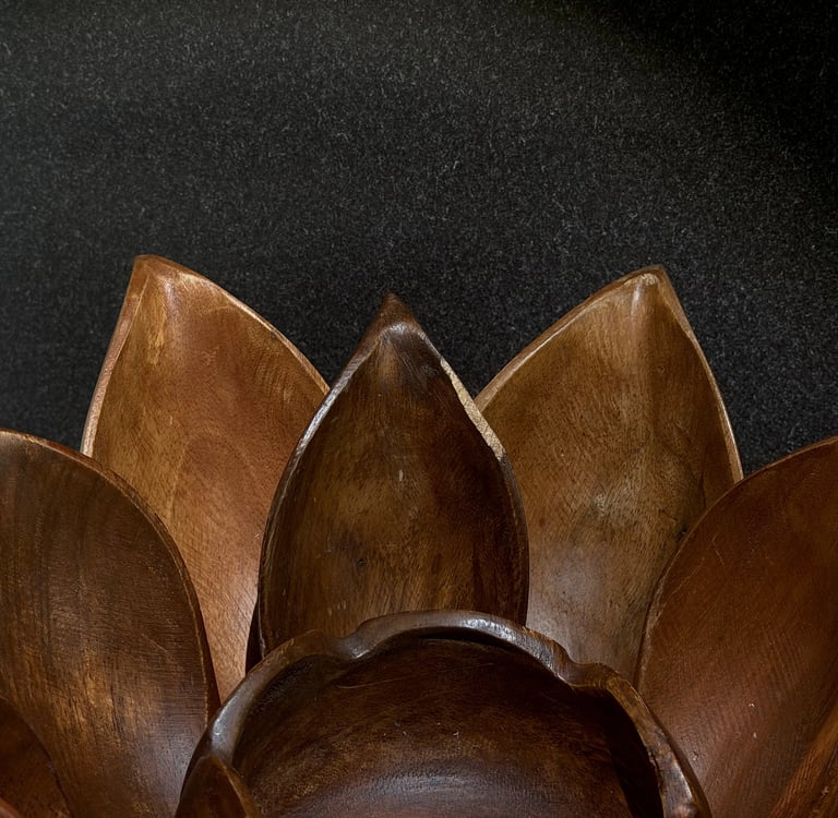 Vintage hanging bamboo wall planter with metal chains casting long shadows on a dimly lit wall.