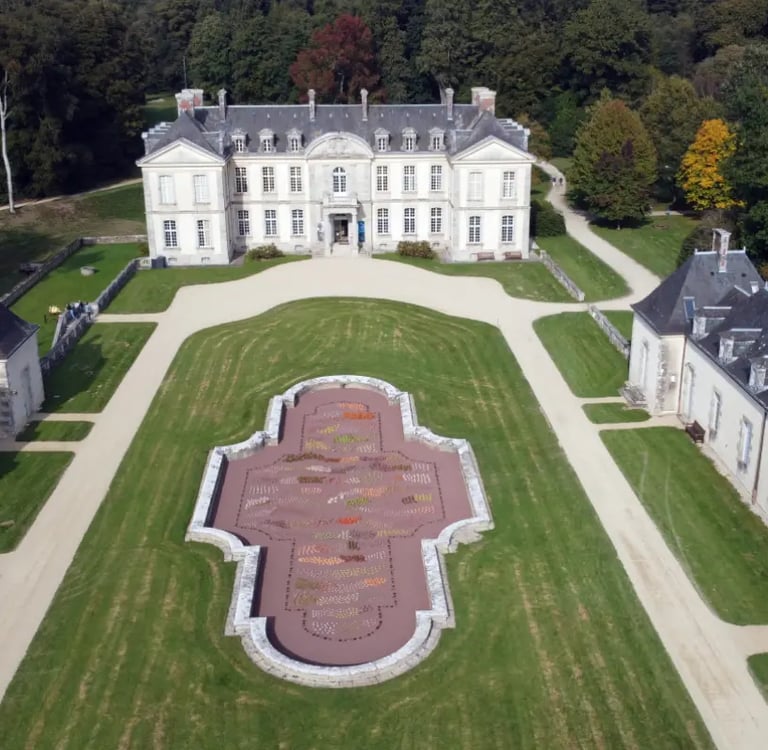 Vue aérienne d'un château français historique avec un jardin à la française et une architecture en p