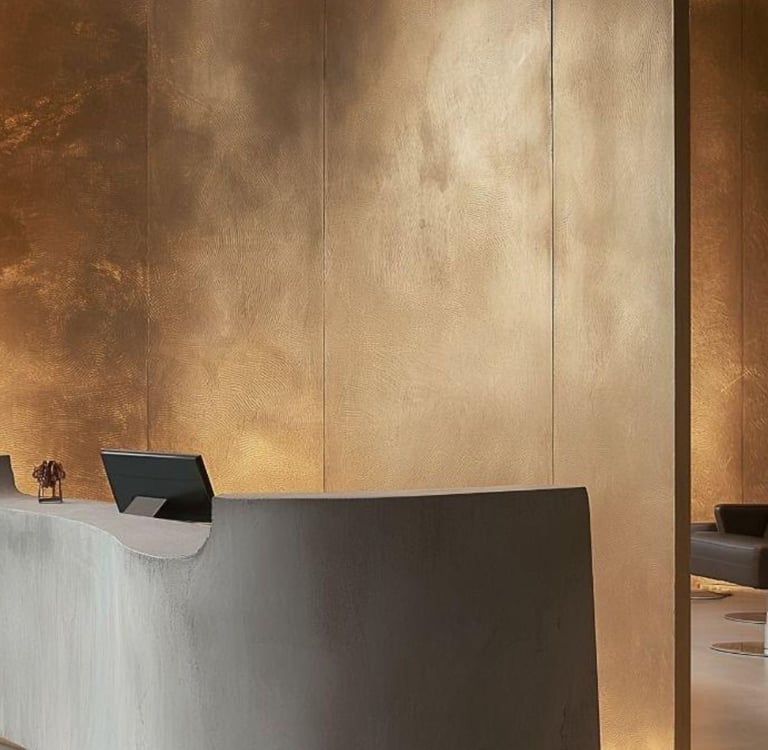 Modern luxury hotel lobby with microcement, featuring a curved stone reception desk against a textur
