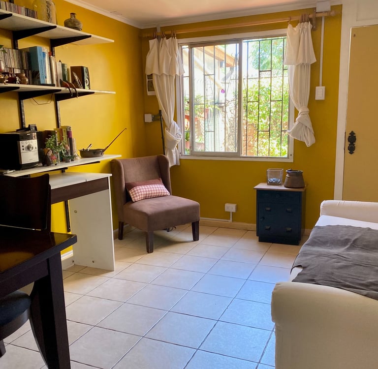 Interior de sala de estar con paredes amarillas y zona de trabajo | proyecto del Studio Atípico