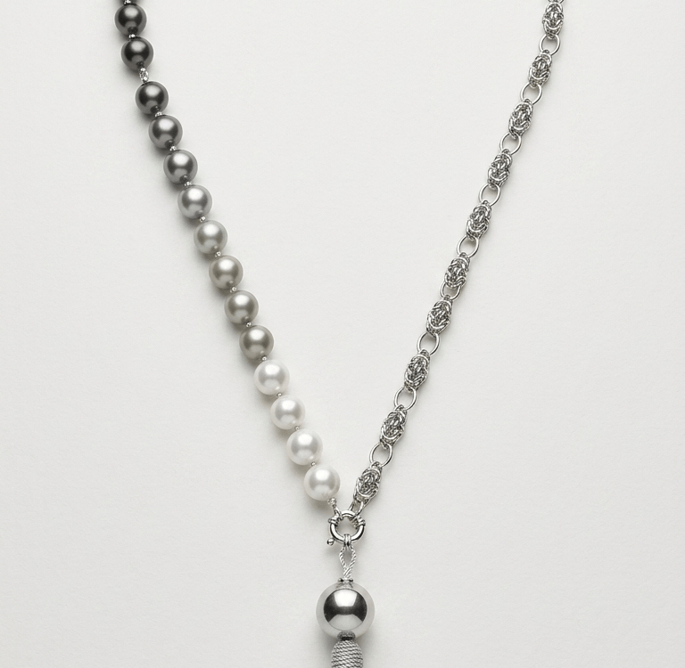 Elegant pearl and silver chain necklace featuring a gradient of grey pearls and a decorative silk tassel pendant.