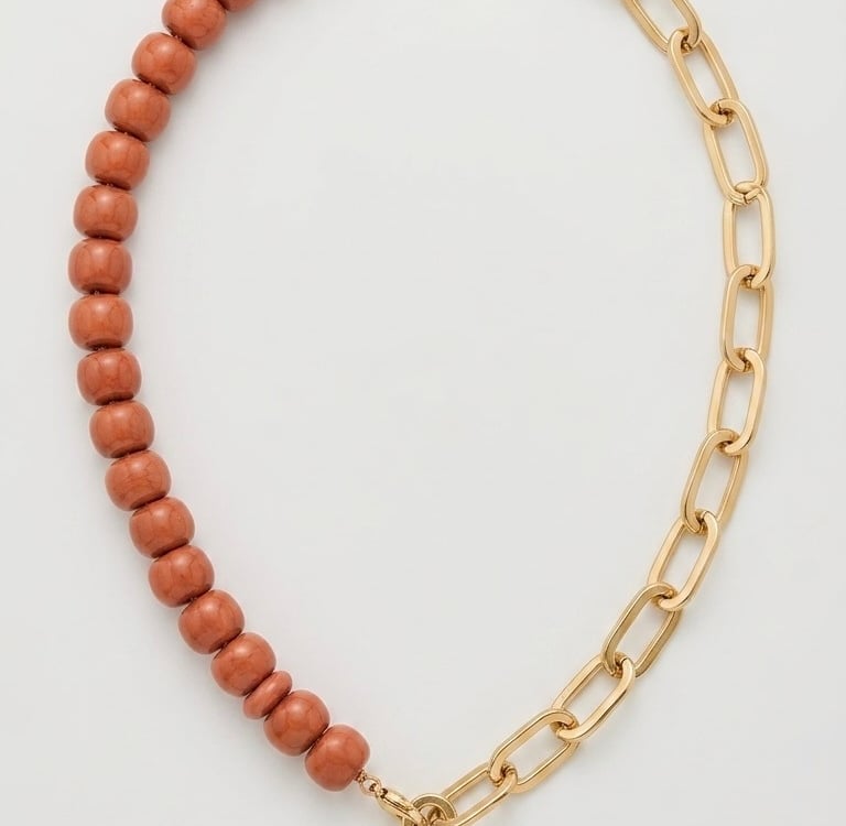 Gold chain necklace with brown beads and a gold heart pendant charm.