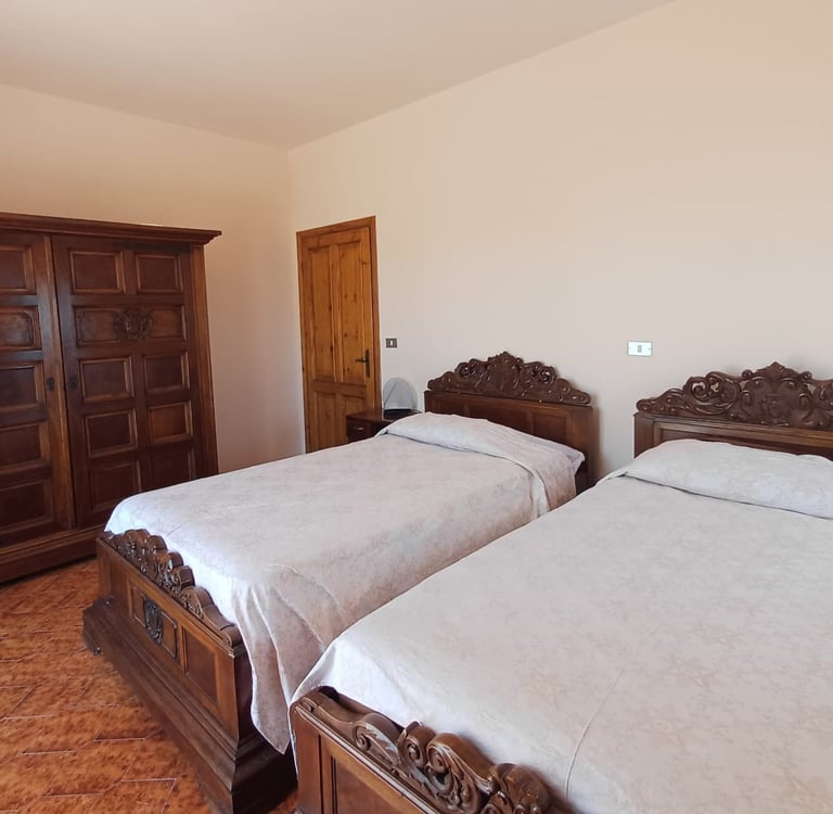 Camera matrimoniale del B&B con arredi classici in legno scuro e atmosfera accogliente.