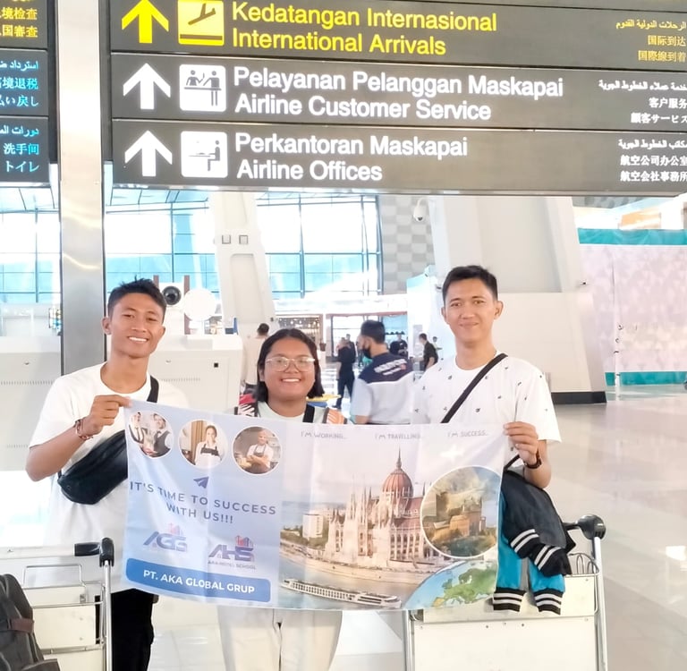 crew posing with AKA banner at an international airport terminal departures sign.
