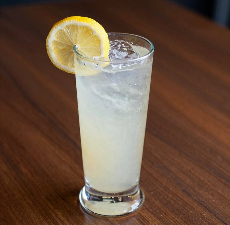 man in blue crew neck t-shirt holding clear drinking glass with orange liquid