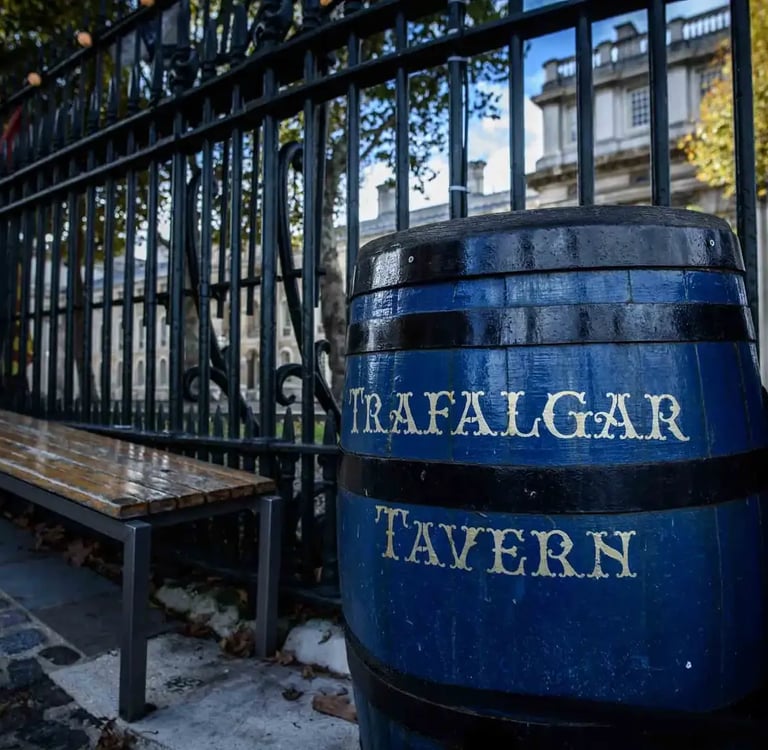 Blue painted barrel with Trafalgar Tavern sign outside a historic London pub in Greenwich.