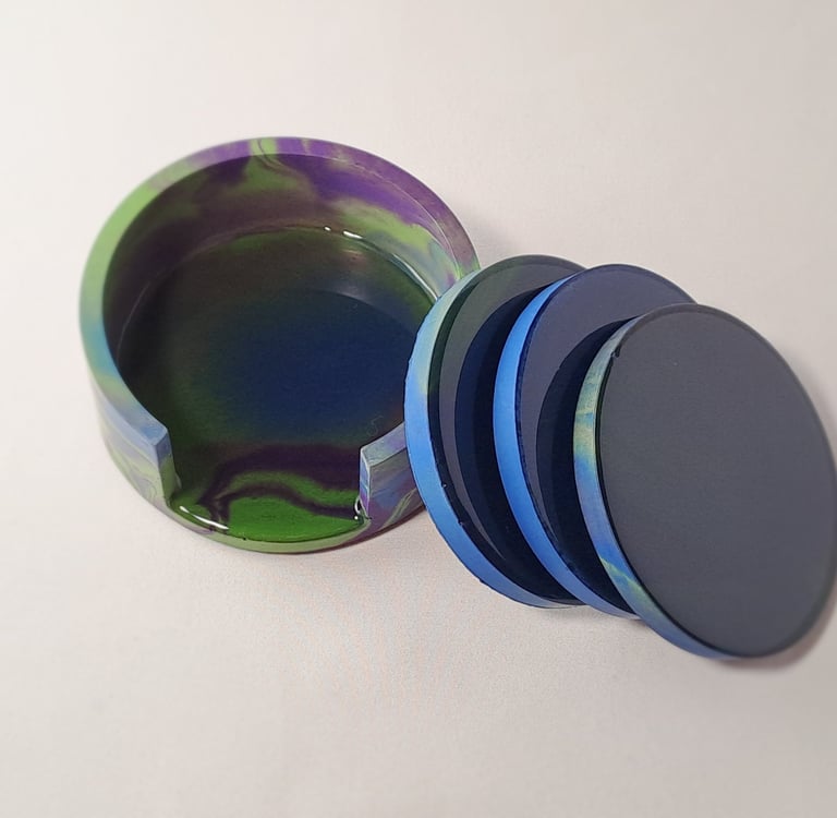 Handmade coasters in blue, purple, and green with a matching holder.