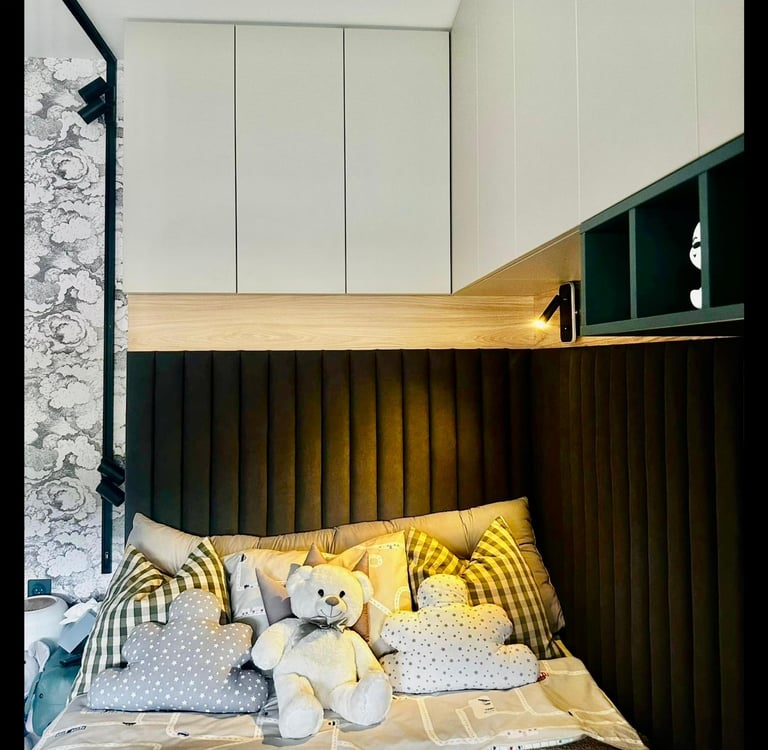 Modern kids bedroom with a built-in bed, black fluted headboard, white storage cabinets, and plush teddy bear toys.