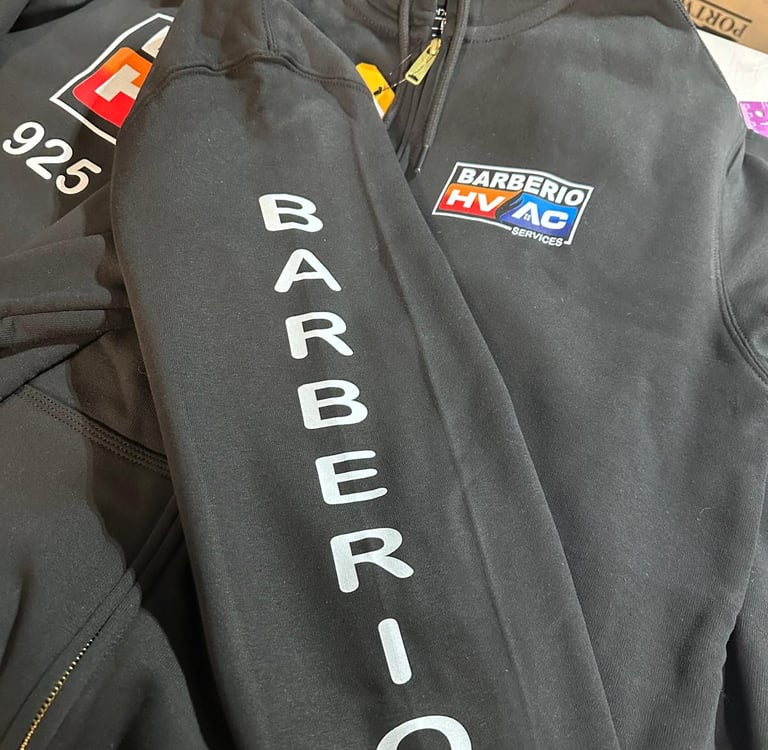 Custom black Barberio HVAC services workwear hoodies featuring printed sleeve logos and chest branding.
