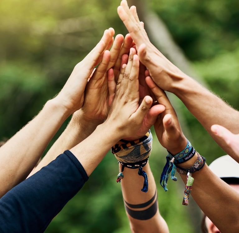 Group of people put their hands together in celebration