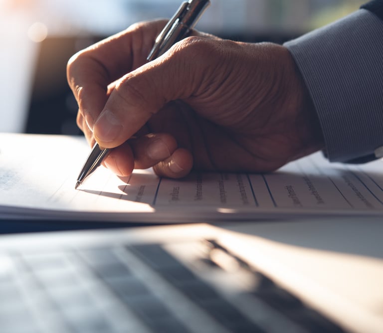 Man signs agreement using a pen on paper