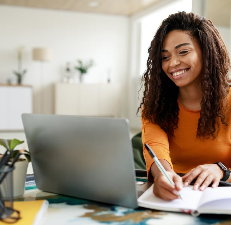 Woman smiles as she speaks to mediator on her laptop