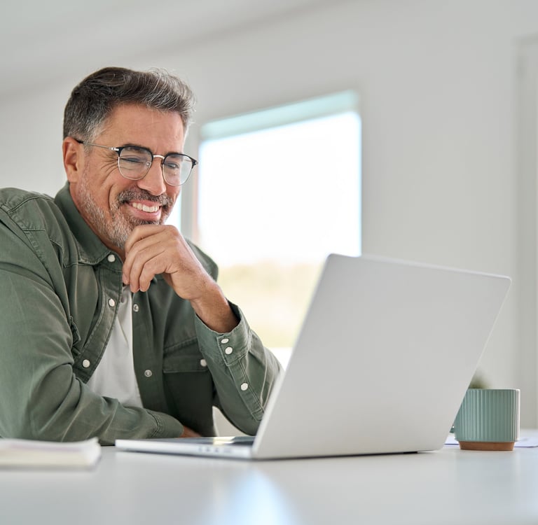 Man smiles as he speaks to mediator on his laptop