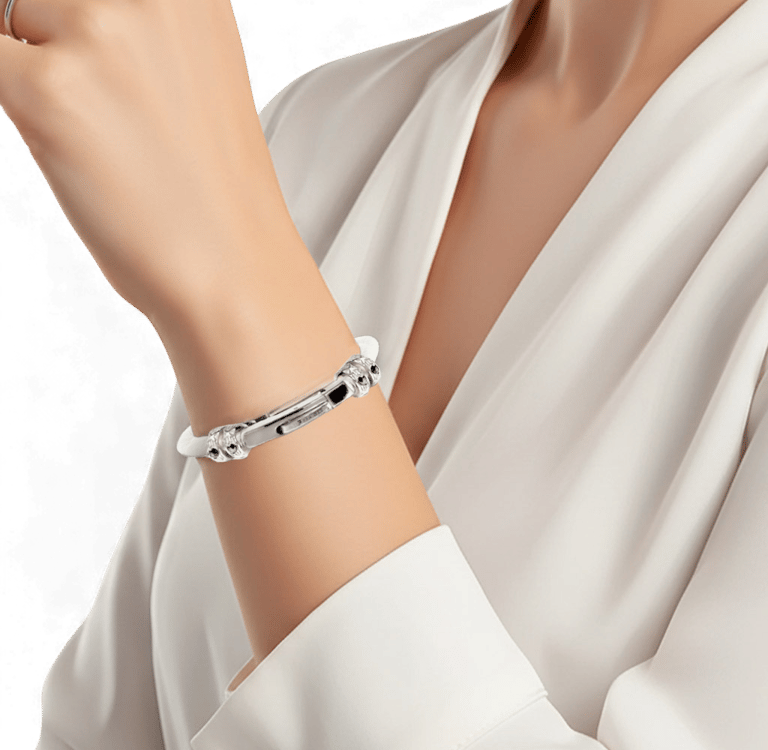 A woman wearing an elegant silver bangle bracelet with intricate clasp detailing on her wrist.