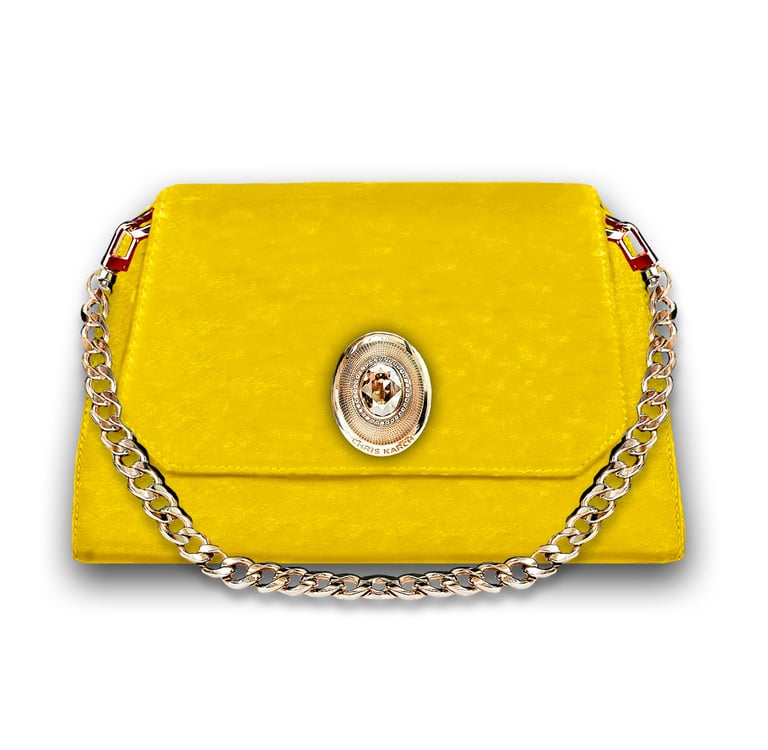 Elegant yellow leather shoulder bag with gold chain strap and ornate metal buckle clasp.