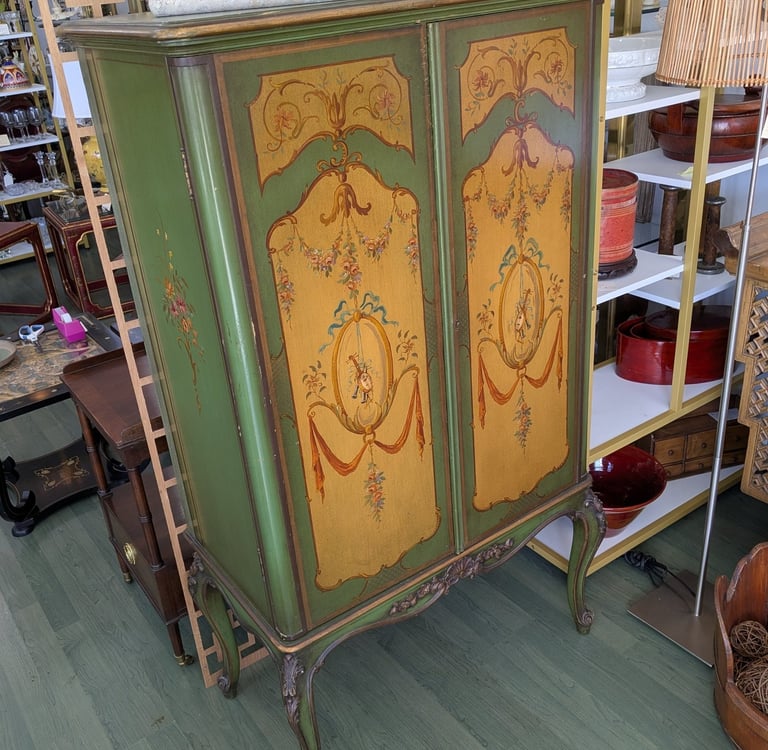 Antique green hand-painted cabinet with floral motifs and elegant cabriole legs.