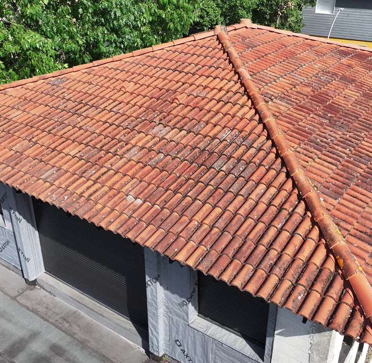 Vue aérienne d'un bâtiment résidentiel avec un toit en argile altérée avec des crêtes de hanche