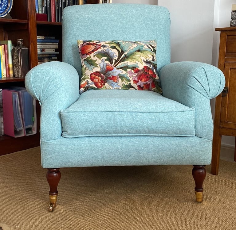 Sillón orejero tapizado en loneta azul celeste conservando patas con ruedas originales. Tenerife