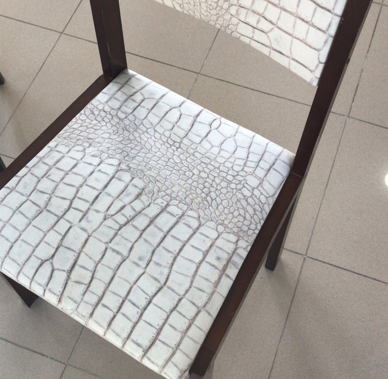 Silla antigua tapizada con terciopelo imitación piel de serpiente integrándola en espacio moderno. 