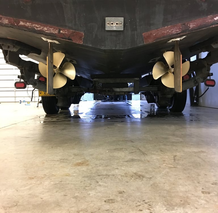 a large boat sitting in a garage props rudders