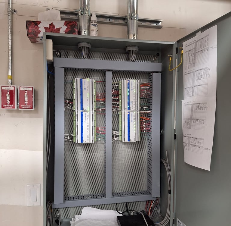 A control panel with iSMA Controlli modules and industrial wiring for HVAC systems.