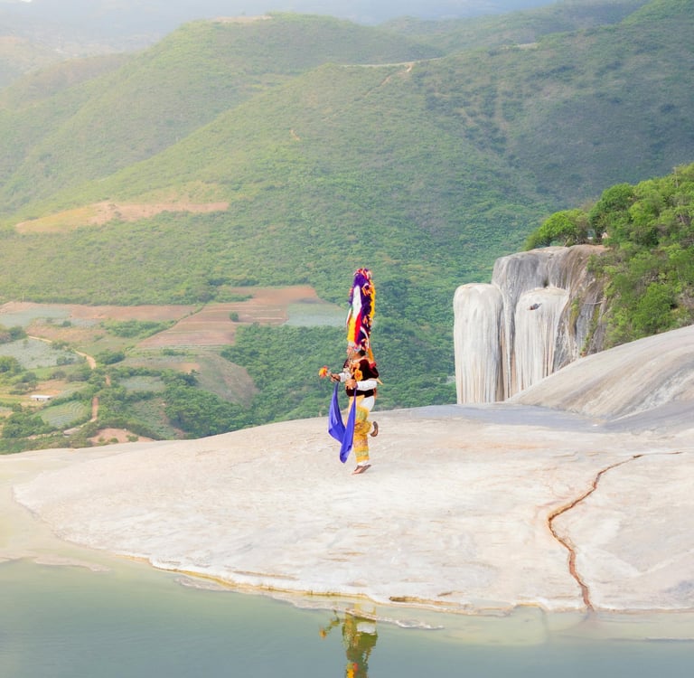 Danzante de la Pluma en Hierve el Agua, Oaxaca, frente a cascadas petrificadas