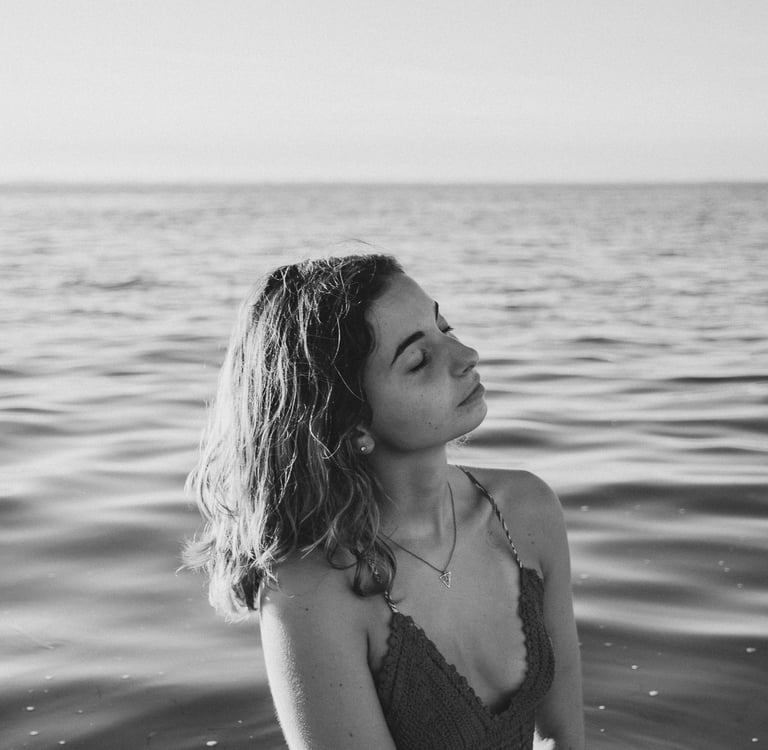 femme dans la mer jusqu'aux hanches fermant les yeux