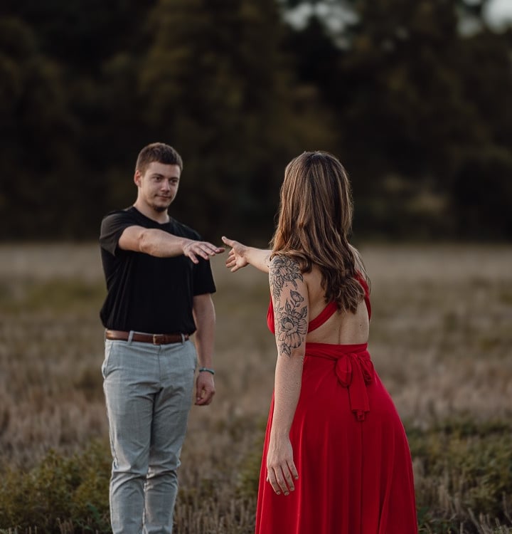 portrait de couple se tendant la main dans un champs