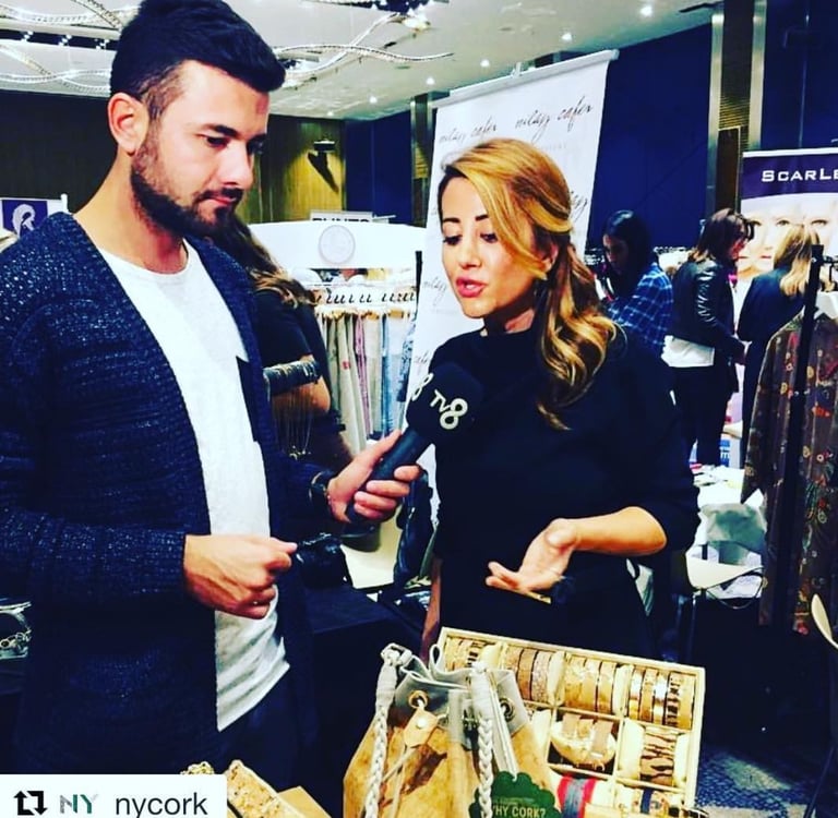 TV8 reporter interviewing Neri Cetin about eco-friendly cork accessories at a boutique trade show.