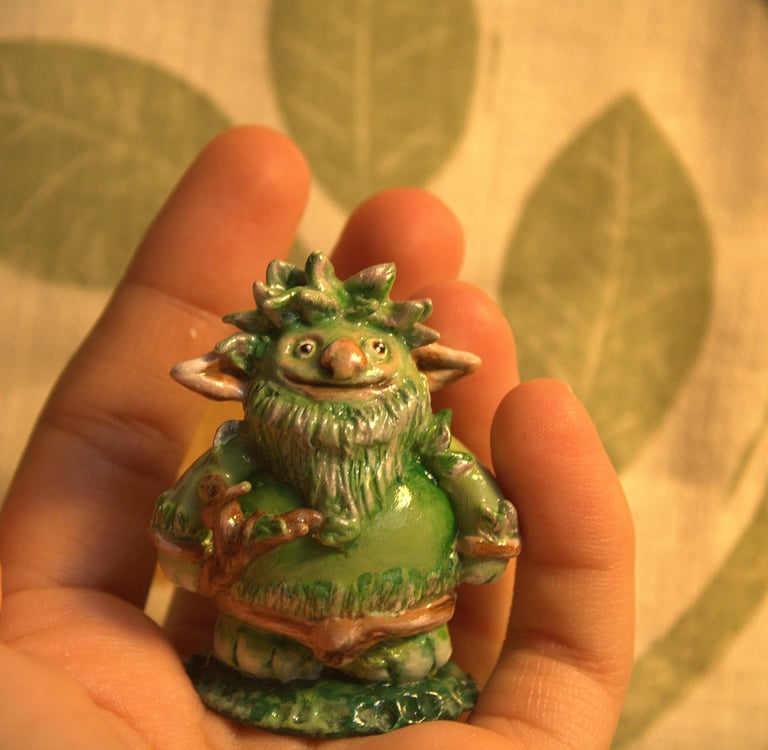 small green troll with leaves sculpted figurine