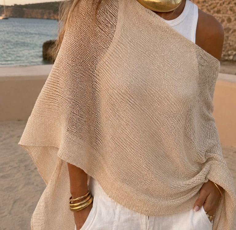 Woman wearing a lightweight beige knit cape top cover up over a white tank top