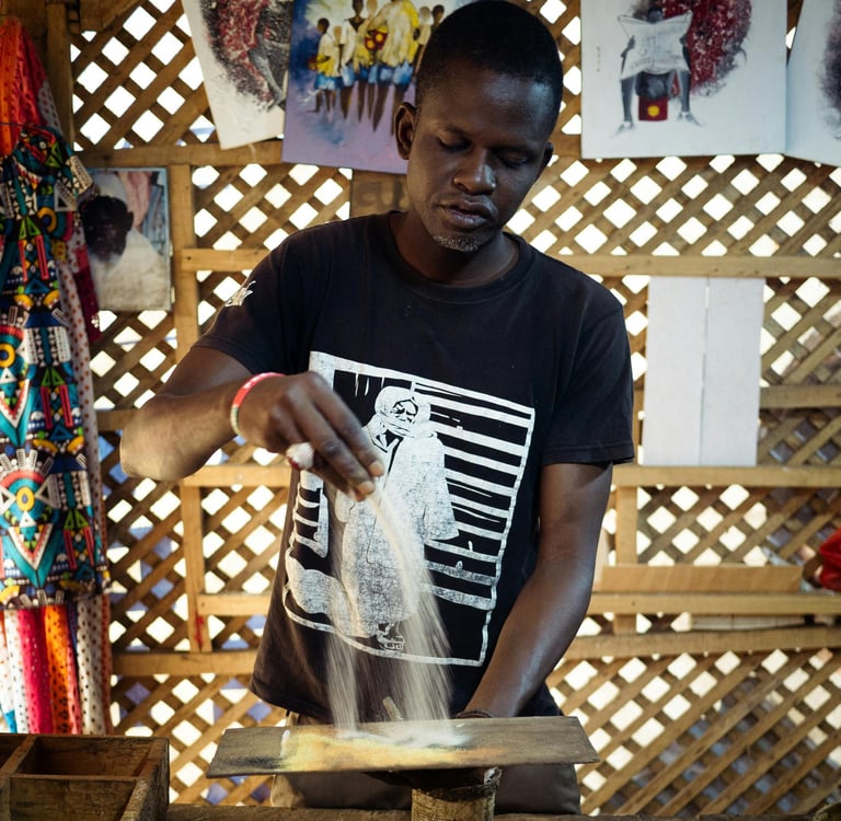 homme faisant de la peinture de sable au sénégal