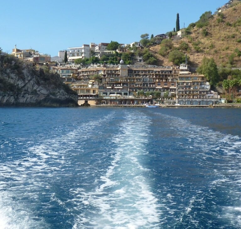 a boat traveling down the water with a view of a city