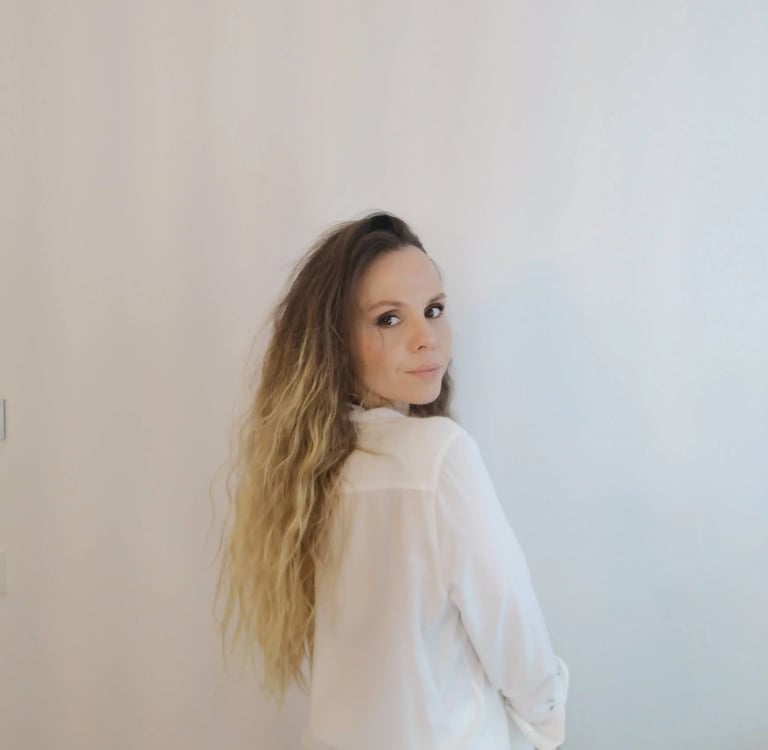 Christine Hauser, RTT Practitioner, looking back over her shoulder in a white shirt, conveying calm 