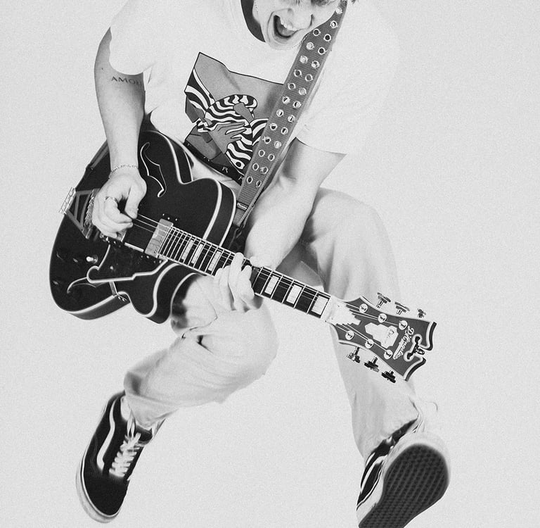 man met gitaar die springt artiest