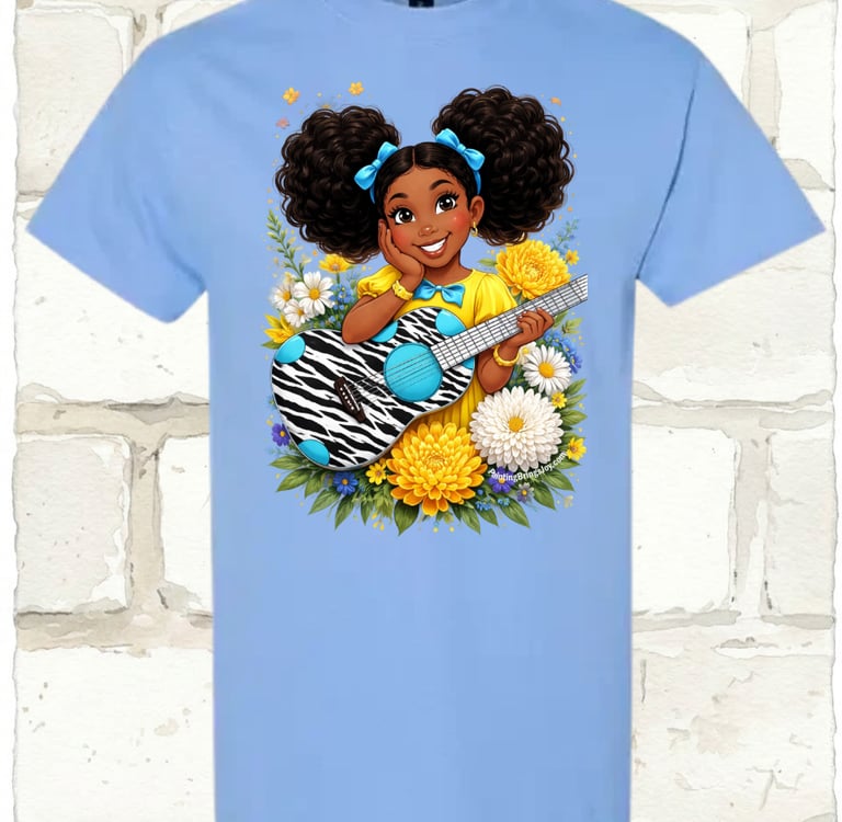 Light blue t-shirt featuring a cartoon girl with puff pigtails holding a zebra print guitar among flowers.